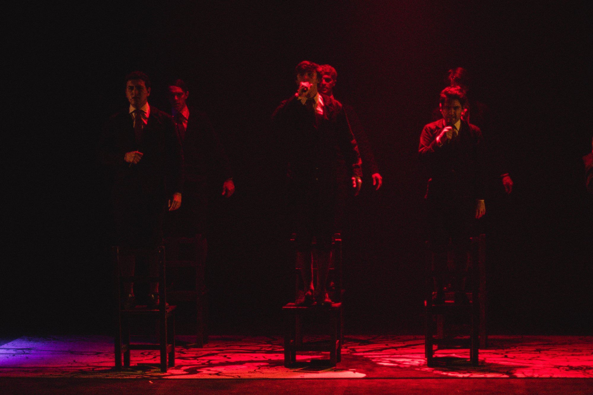 Escena con luz roja: el ensamble de pie, en línea.