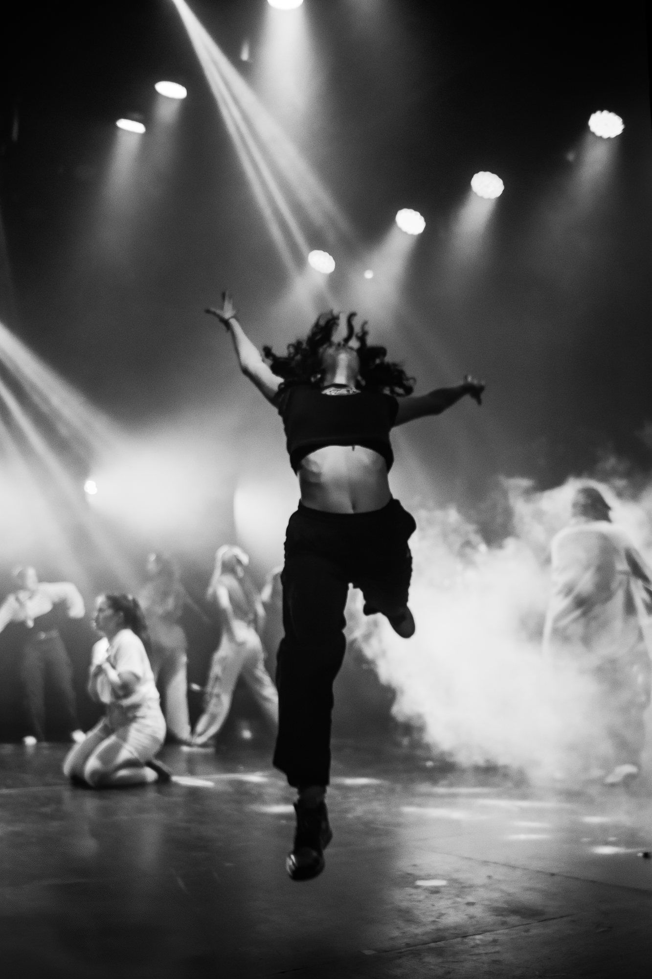 En blanco y negro: una bailarina salta entre el humo.